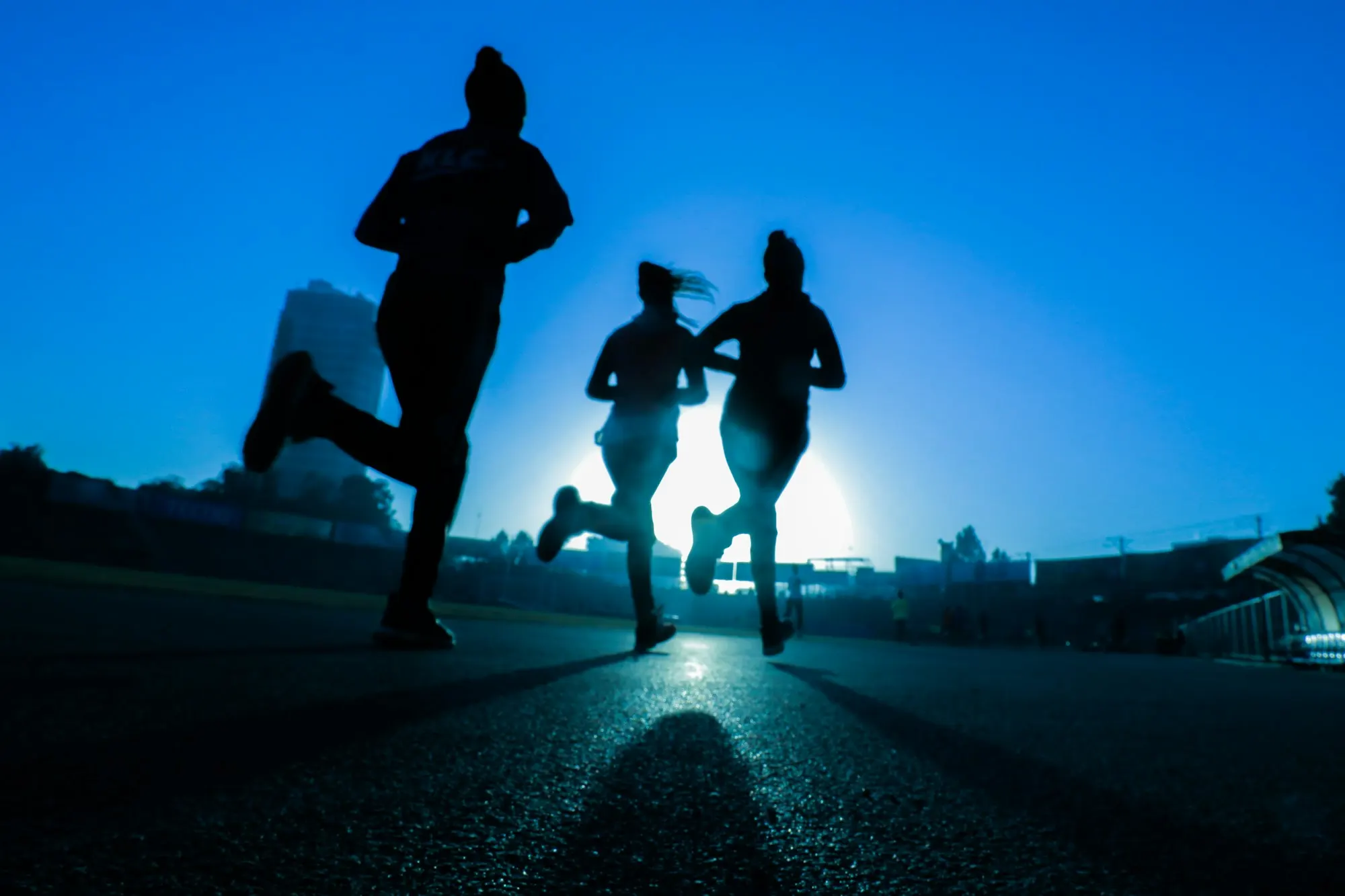 Three women running at dusk