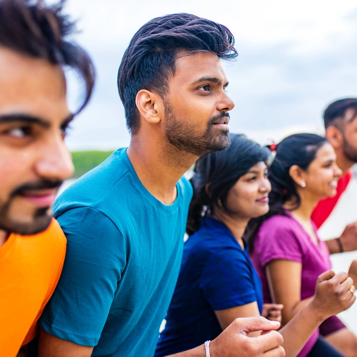 A crew of friends cheering together outdoors